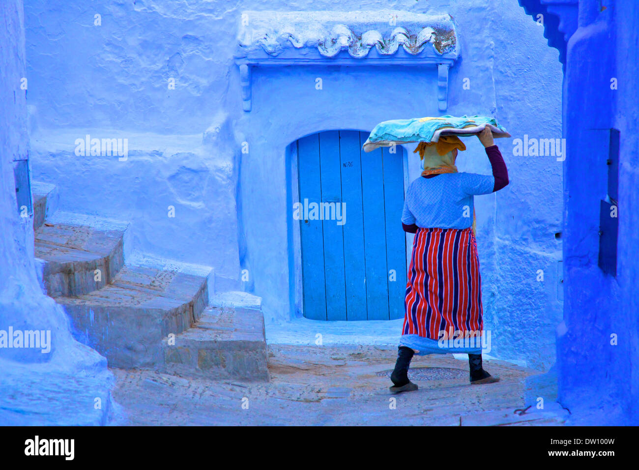 Femme en costume traditionnel portant un plateau de pâte à pain, Chefchaouen, Maroc, Afrique du Nord Banque D'Images