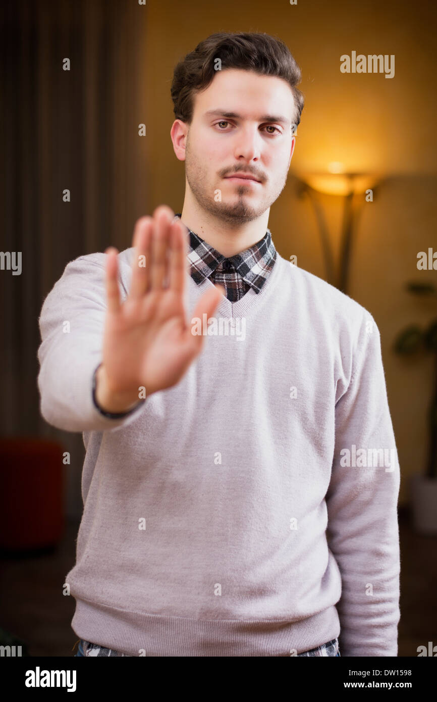 Beau jeune homme seerious faisant stop avec sa main avec une expression sévère. Banque D'Images