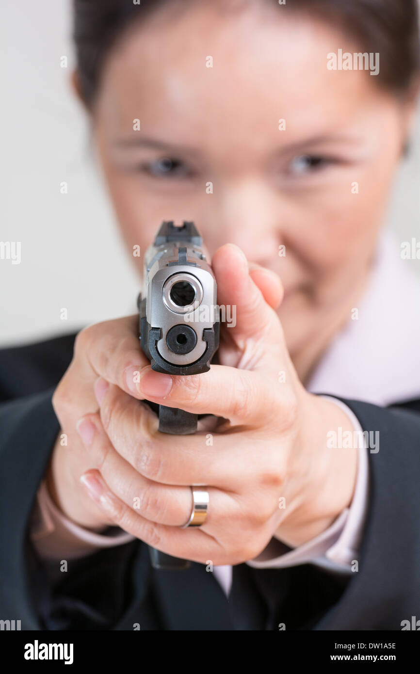 Femme visant une arme de poing Banque D'Images
