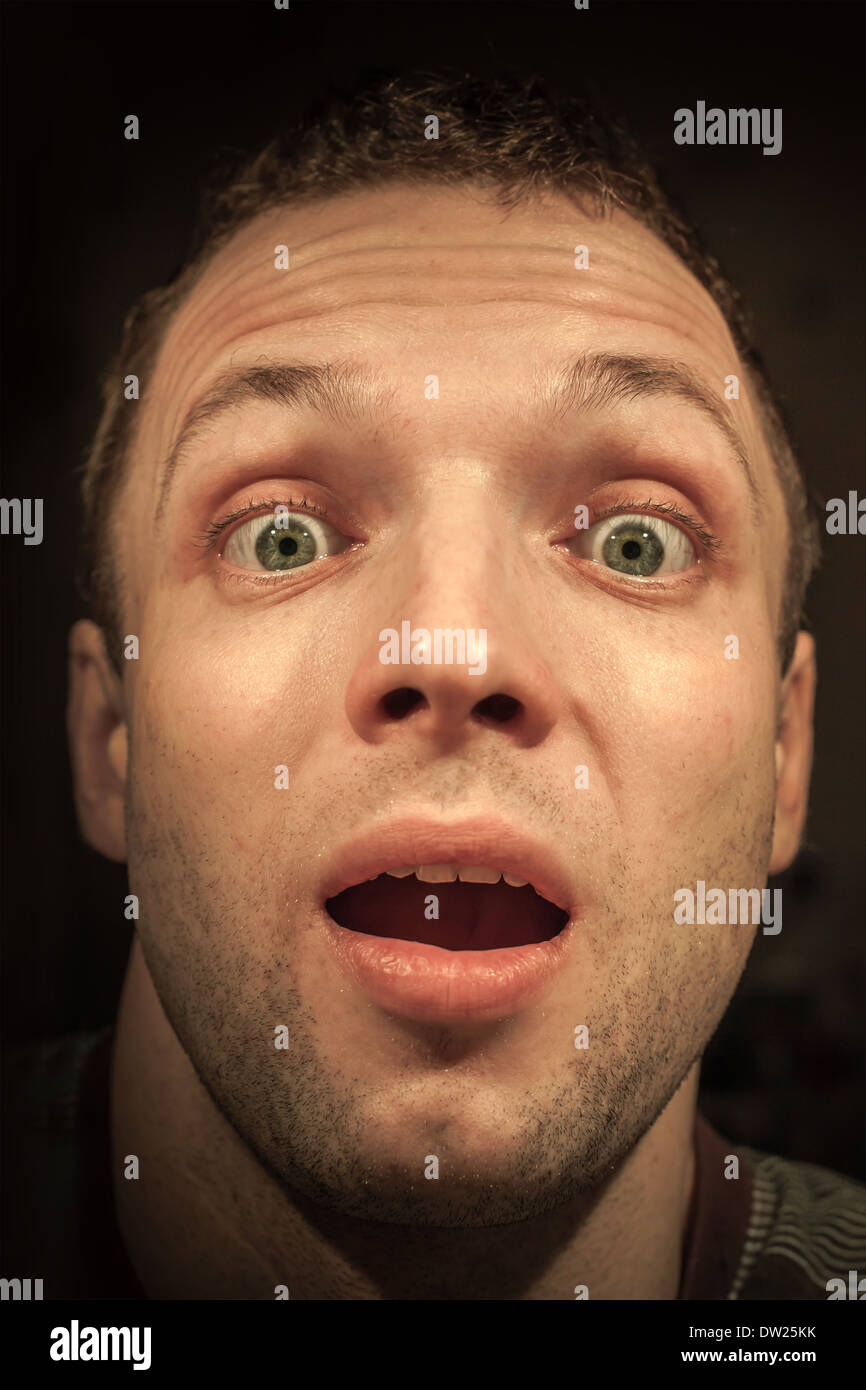 Les jeunes choqués Caucasian man closeup portrait sur fond sombre Banque D'Images