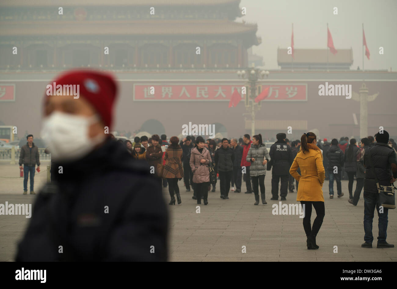Un homme porte un masque à la place Tiananmen à Pékin le 26 février 2014. La pollution atmosphérique a enveloppé certaines parties de la Chine du Nord-Est depuis vendredi dernier, les résidents de quitter l'étouffement sur les niveaux de smog dangereux Crédit : Lou Linwei/Alamy Live News Banque D'Images