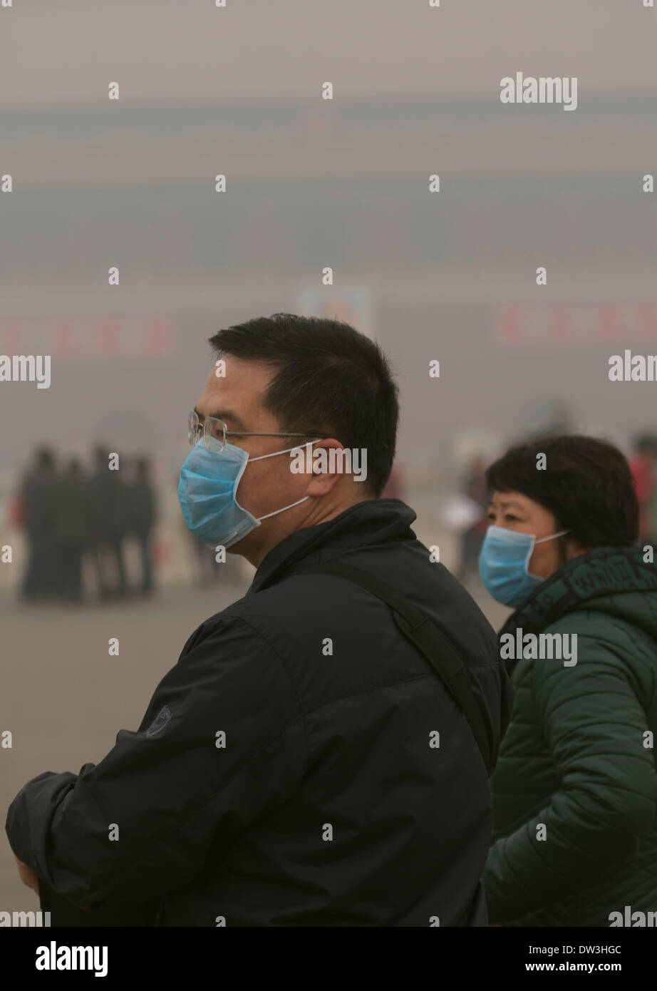 Les touristes portent des masques à la place Tiananmen à Pékin le 26 février 2014. La pollution atmosphérique a enveloppé certaines parties de la Chine du Nord-Est depuis vendredi dernier, les résidents de quitter l'étouffement sur les niveaux de smog dangereux. Credit : Lou Linwei/Alamy Live News Banque D'Images