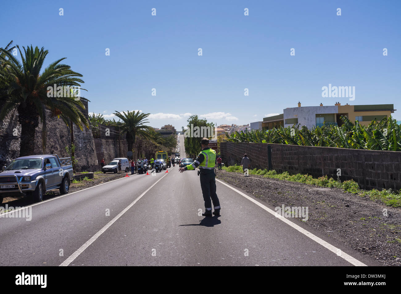 Un policier de la Guardia Civil Trafico, direcing véhicules autour de la scène d'un accident de la route près de Playa San Juan, sur l'île de Tenerife Banque D'Images