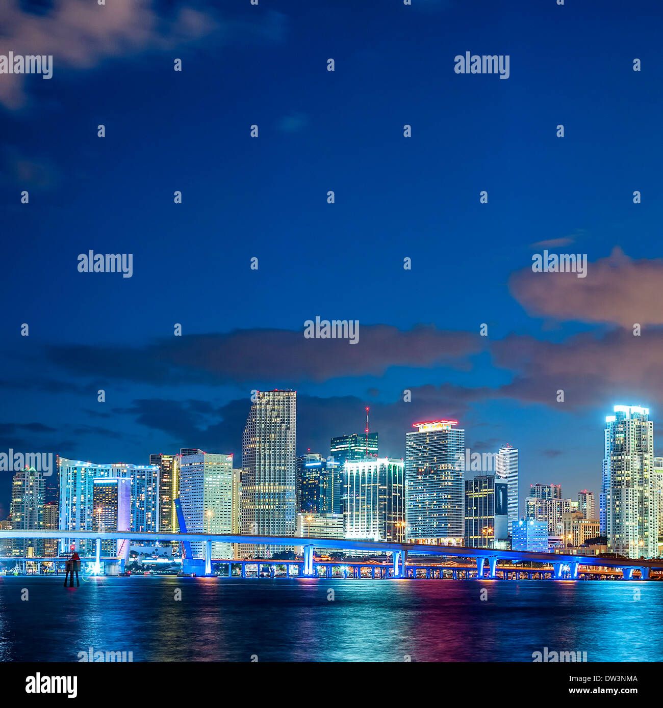 Miami, Floride, coucher avec des bâtiments résidentiels et d'affaires éclairées et pont sur Biscayne Bay Banque D'Images