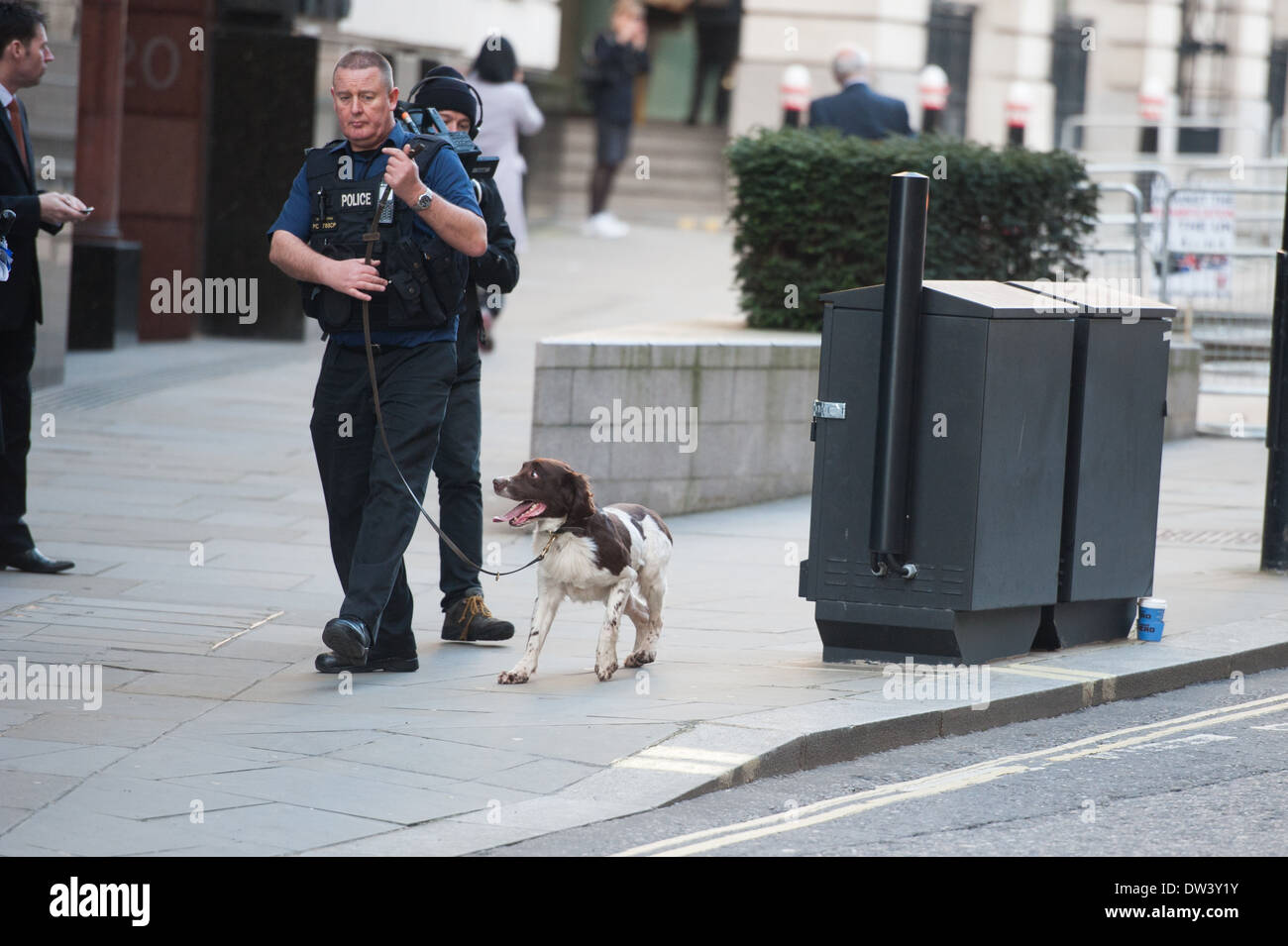 Les agents de police promenades autour d'un chien de recherche dans la ville de Londres, près de l'Old Bailey. Banque D'Images