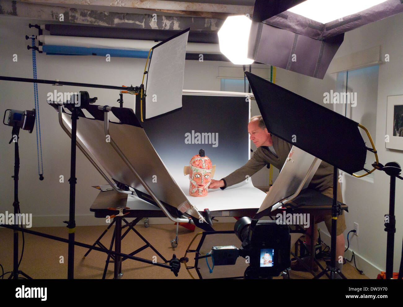 Photographe travaillant dans un studio de photographie commerciale, avec l'éclairage, l'arrière-plan et l'adhérence. Banque D'Images