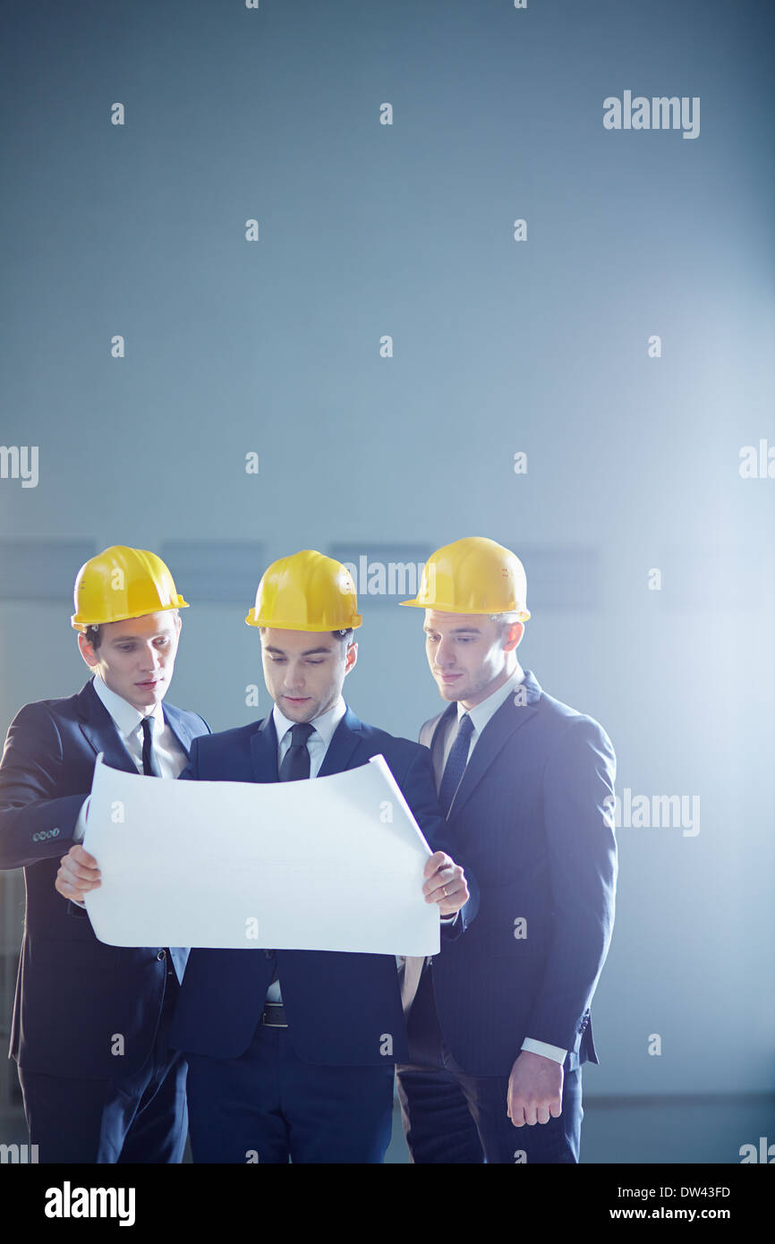 Interligne copie image d'une construction de trois travailleurs en possession d'un projet et de discuter d'une chose Banque D'Images