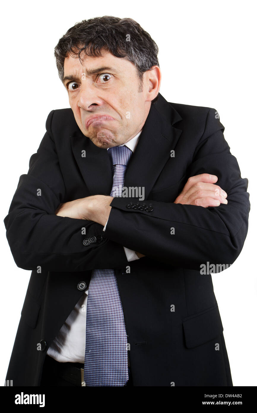 Malheureux businessman standing avec ses bras croisés et grimaçant à dévorant l'appareil photo avec une expression maussade, isolé Banque D'Images