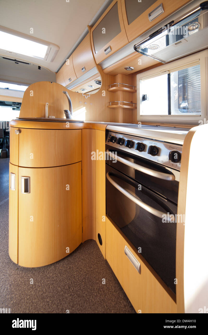 Le camping-car de l'Intérieur : cuisine équipée cuisinière avec four et  armoires en bois Photo Stock - Alamy
