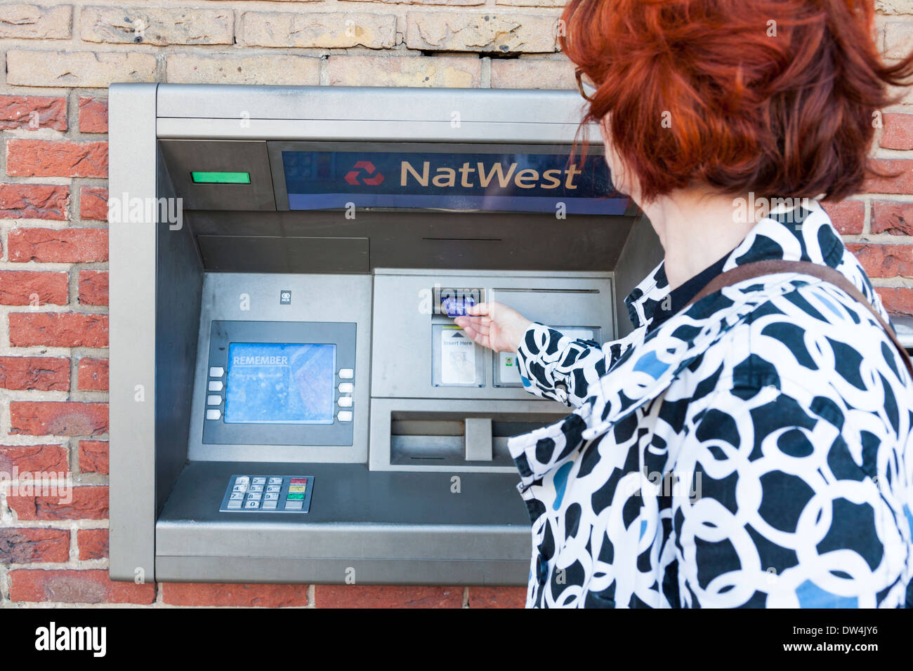 Femme à l'aide d'un distributeur automatique de billets à la banque NatWest, Lancashire, England, UK Banque D'Images