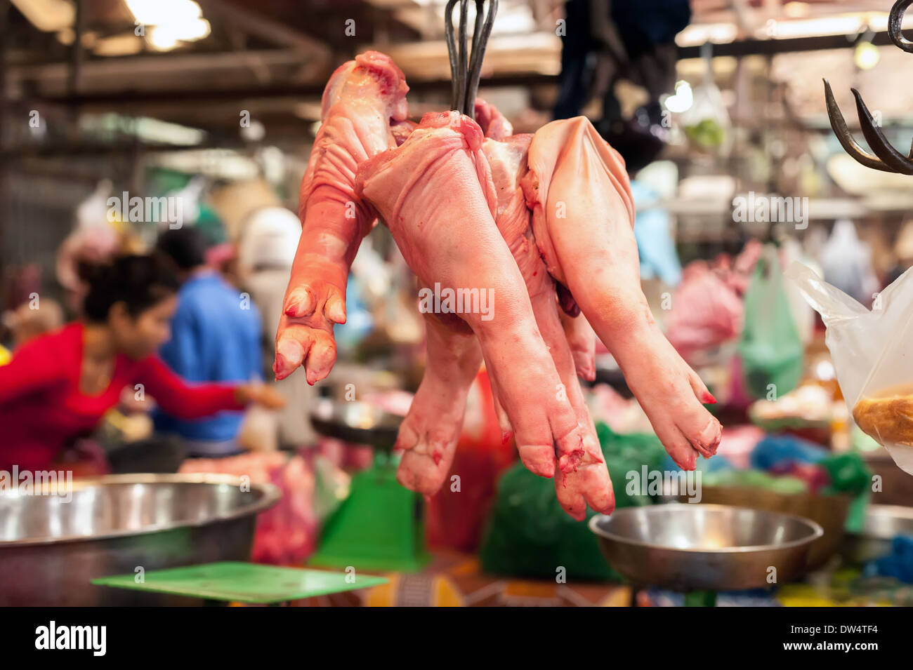 Les jambes de porc cru à vendre au marché des aliments asiatiques suspendus. Cambodge Banque D'Images