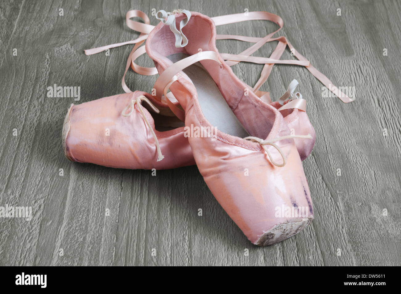 Vieux rose utilisé chaussures de ballet sur fond de bois Banque D'Images