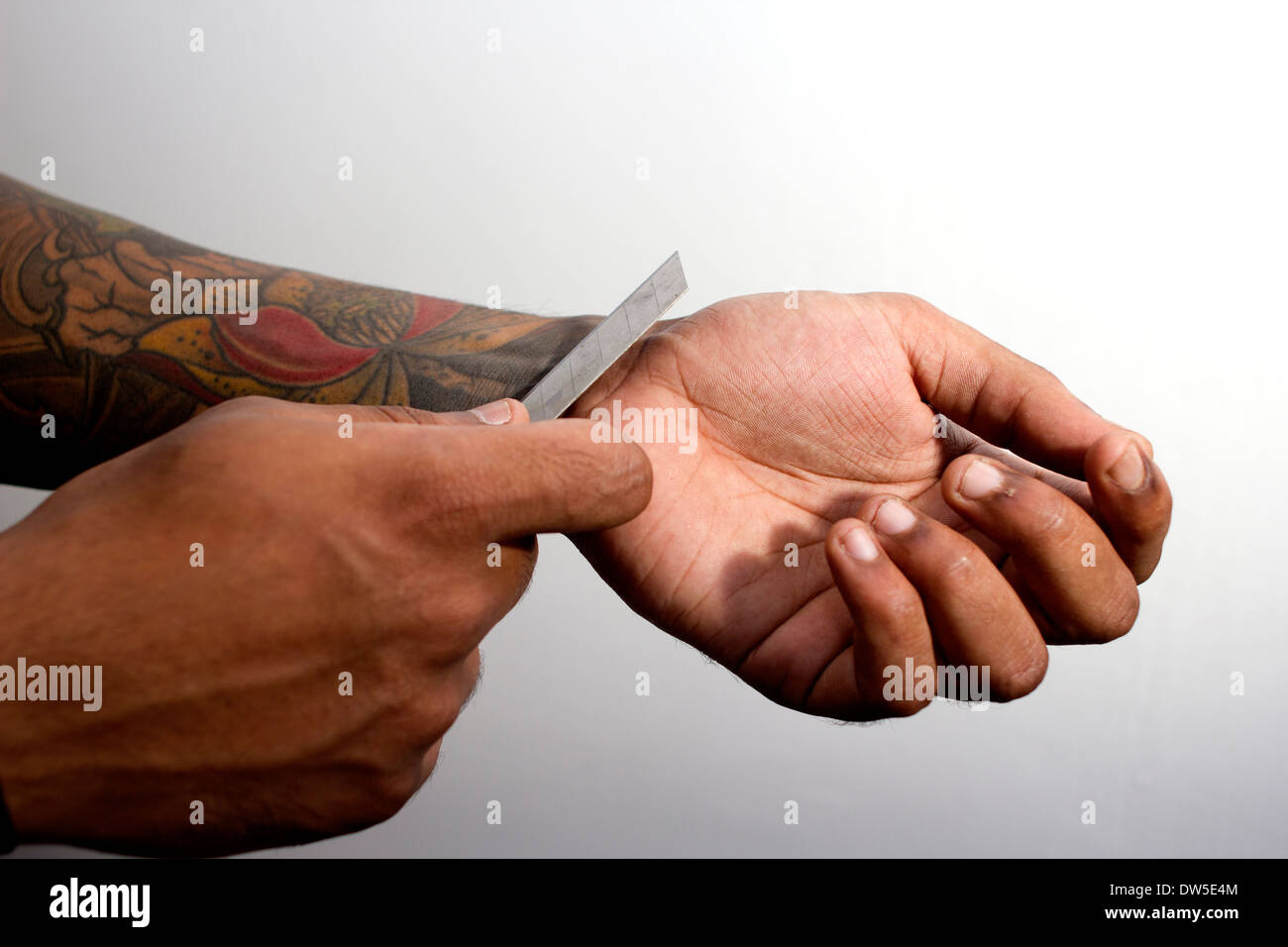 Homme avec des tatouages poignet refendage Banque D'Images