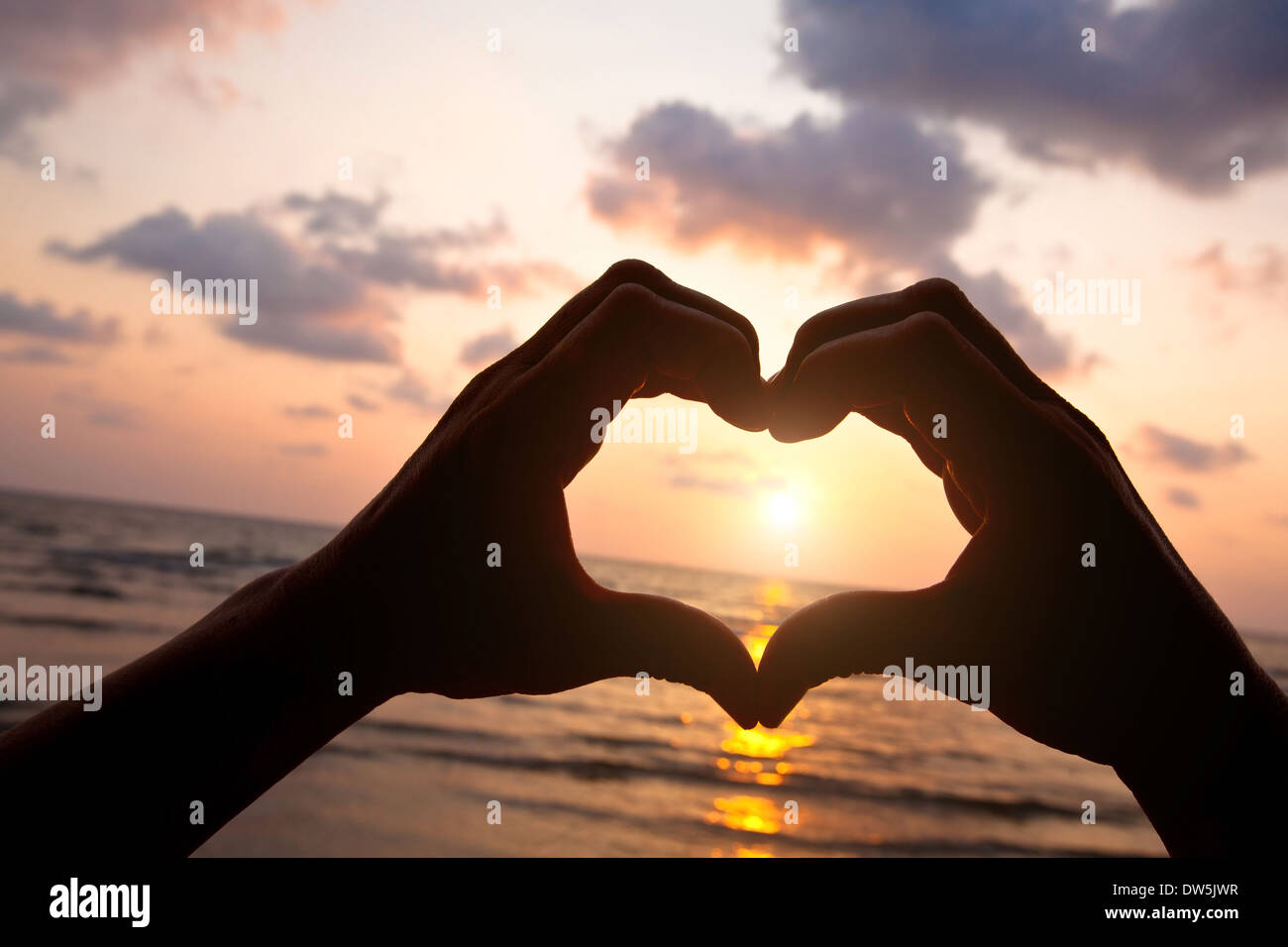 Coeur de mains de couple sur la plage Banque D'Images