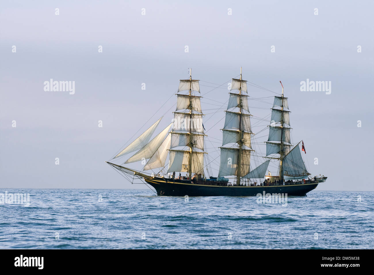 Navire avec voiles blanches dans la mer calme Banque D'Images
