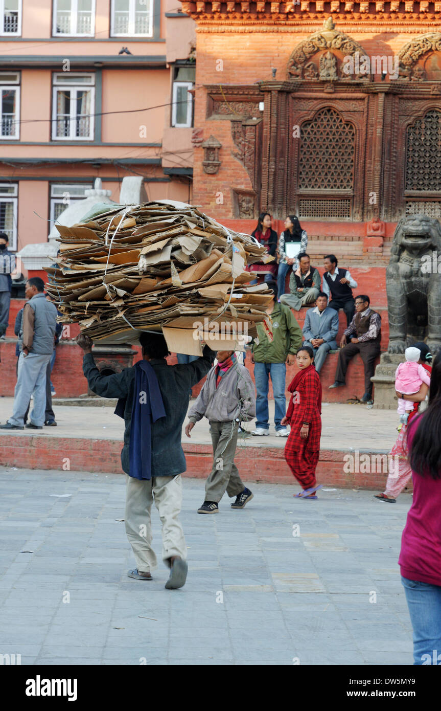 Un homme portant une énorme charge de carton pour recyclage à Katmandou au Népal Banque D'Images