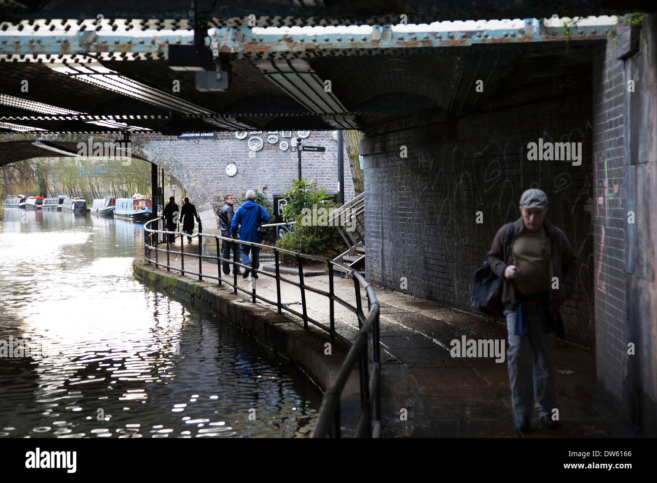Les gens qui marchent le long du chemin de halage sous les ponts plus global Regents Canal à Camden Town, Londres, Royaume-Uni. Banque D'Images