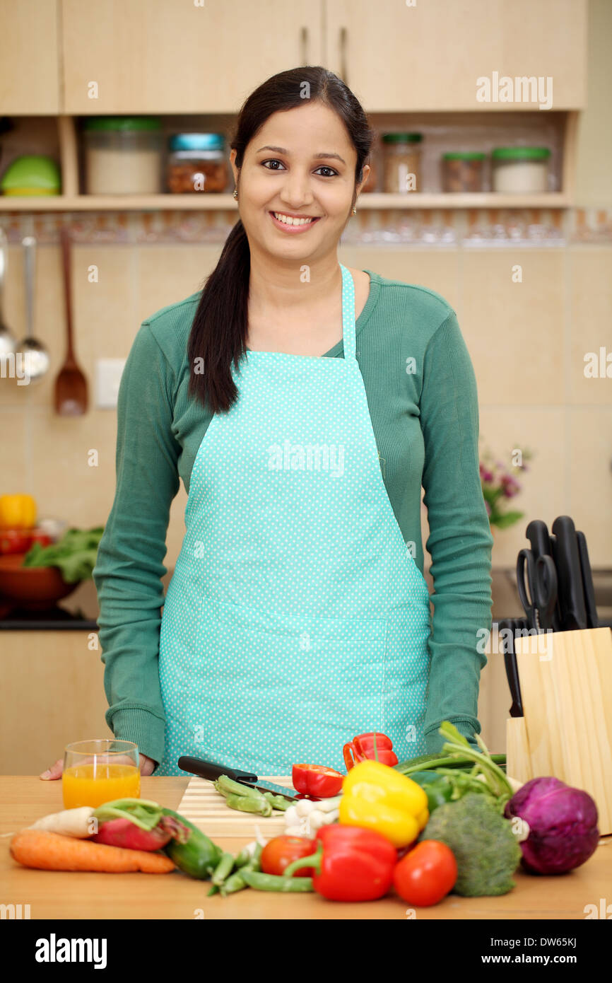 Souriante jeune femme indienne dans sa cuisine Banque D'Images