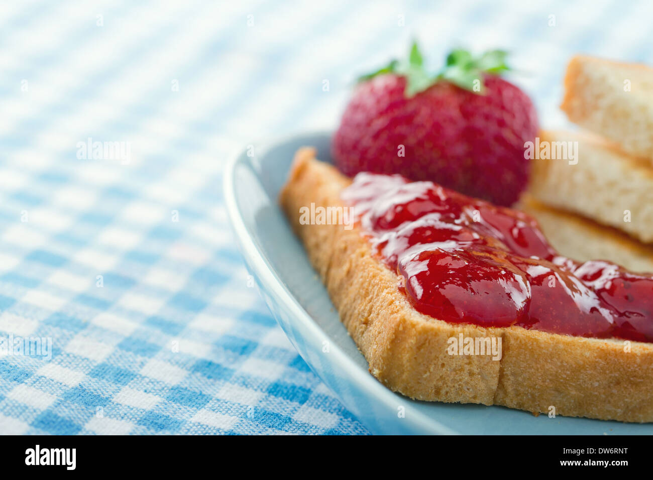 Tranches de pain grillé avec de la confiture de fraises rouges et de baies fraîches sur fond bleu vintage Banque D'Images