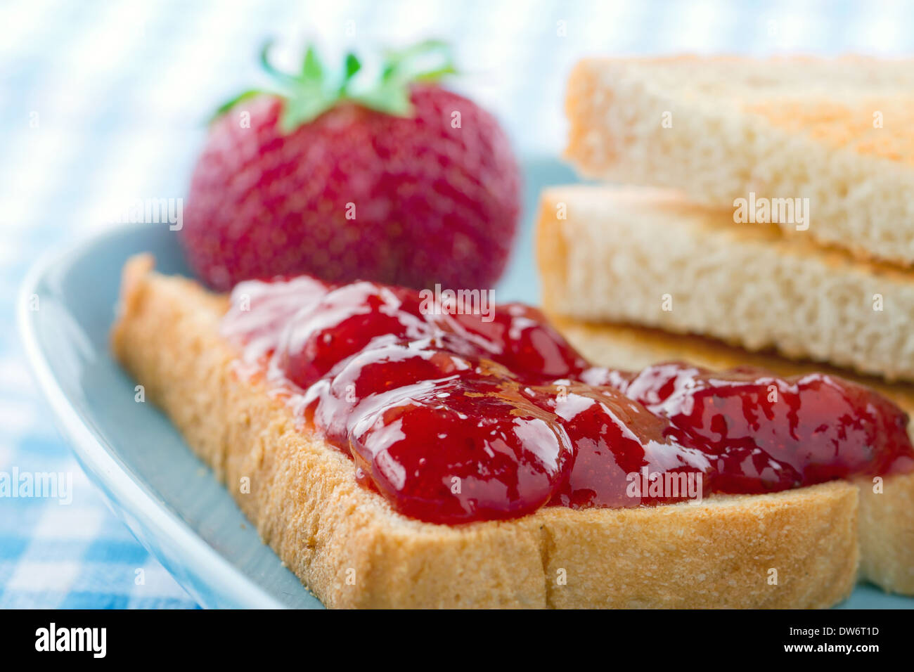 Tranches de pain grillé avec de la confiture de fraises rouges et de baies fraîches sur fond bleu vintage Banque D'Images