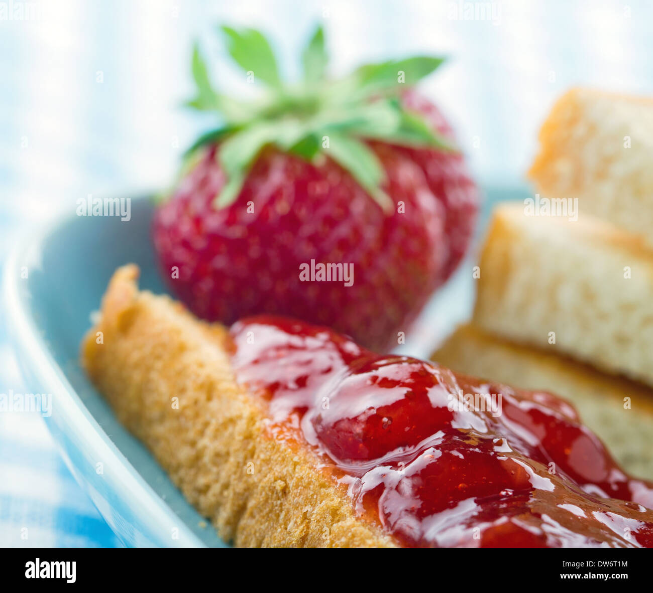 Tranches de pain grillé avec de la confiture de fraises rouges et de baies fraîches sur fond bleu vintage Banque D'Images