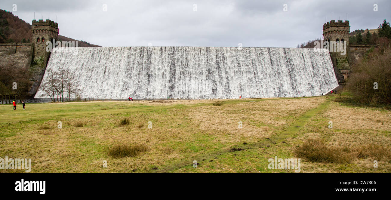 Réservoir Derwent dans le Derbyshire Peak avec de l'eau cascade sur le mur de barrage après plusieurs mois de pluie d'hiver en 2013/14 Banque D'Images