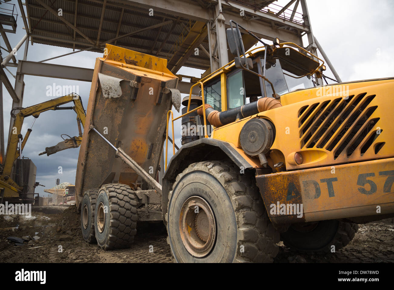 Un camion benne volvo cuivre conseils et le minerai d'or dans un broyeur dans une grande mine d'or/ cuivre coulé en Afrique Banque D'Images