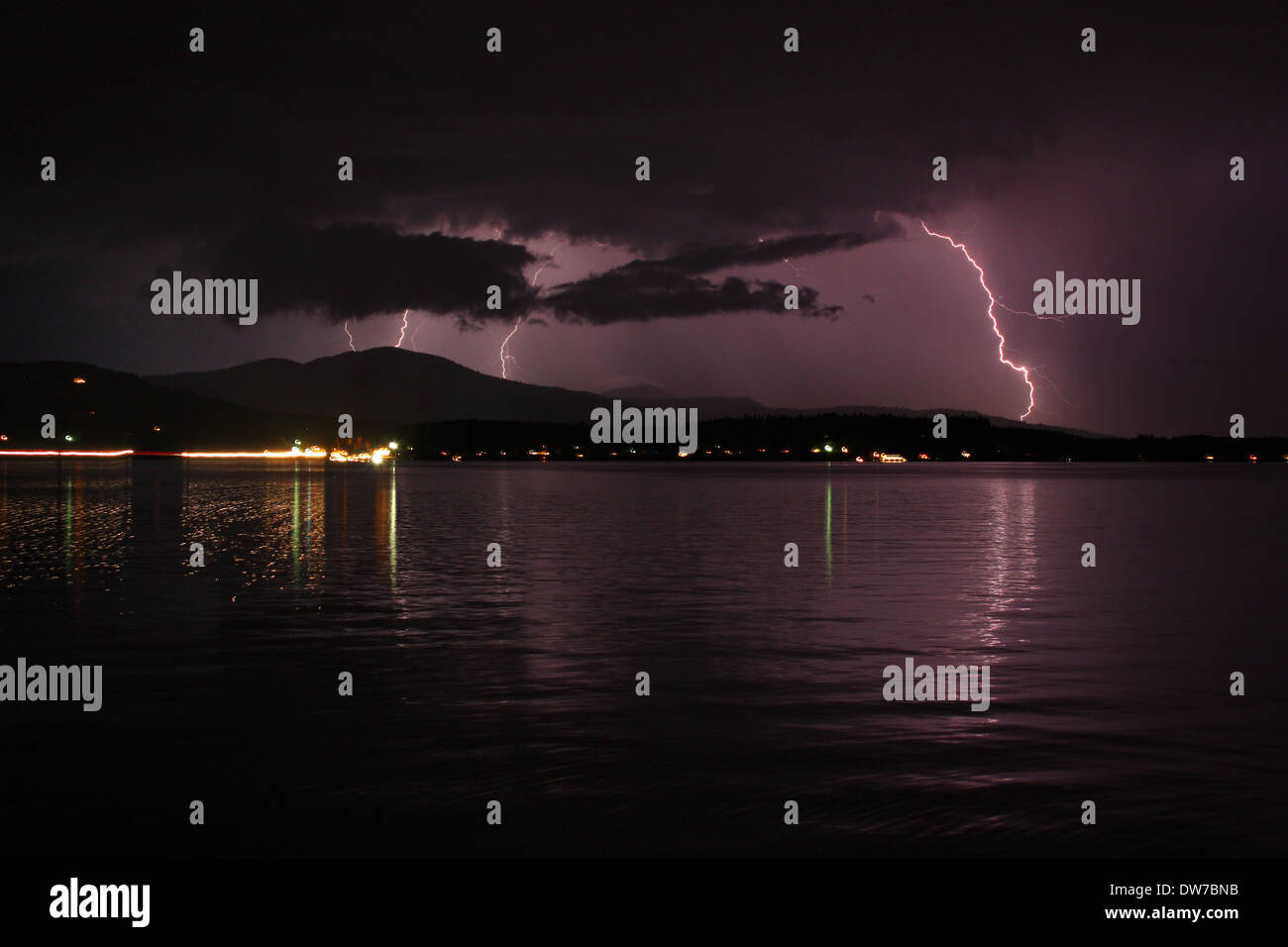 Thunder & éclairage tempête dans le ciel nocturne nuageux, pourpre, reflétant sur l'eau du lac dans la région de Sandpoint Idaho. Banque D'Images