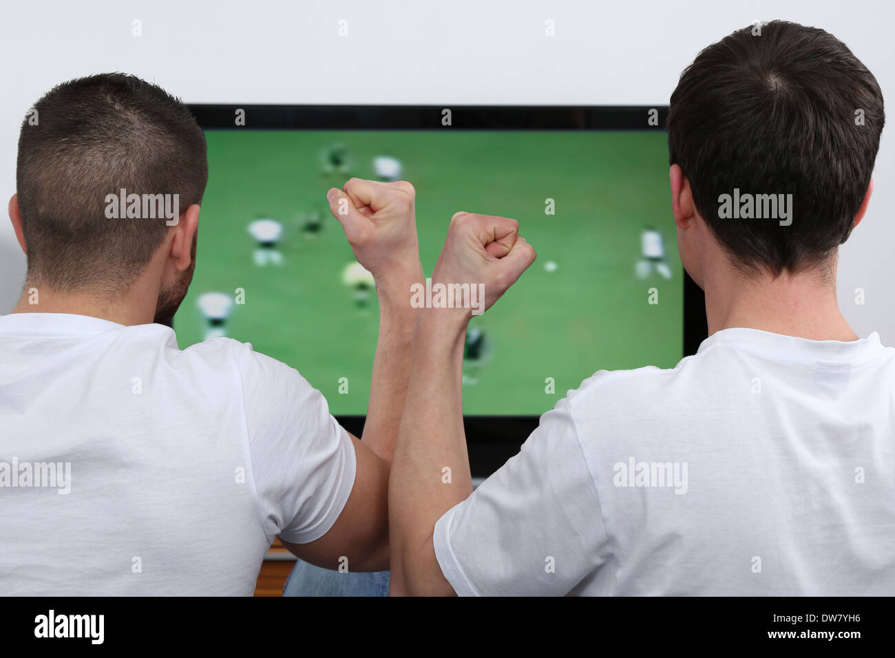 Les jeunes gens à l'écoute de football à la télévision Banque D'Images