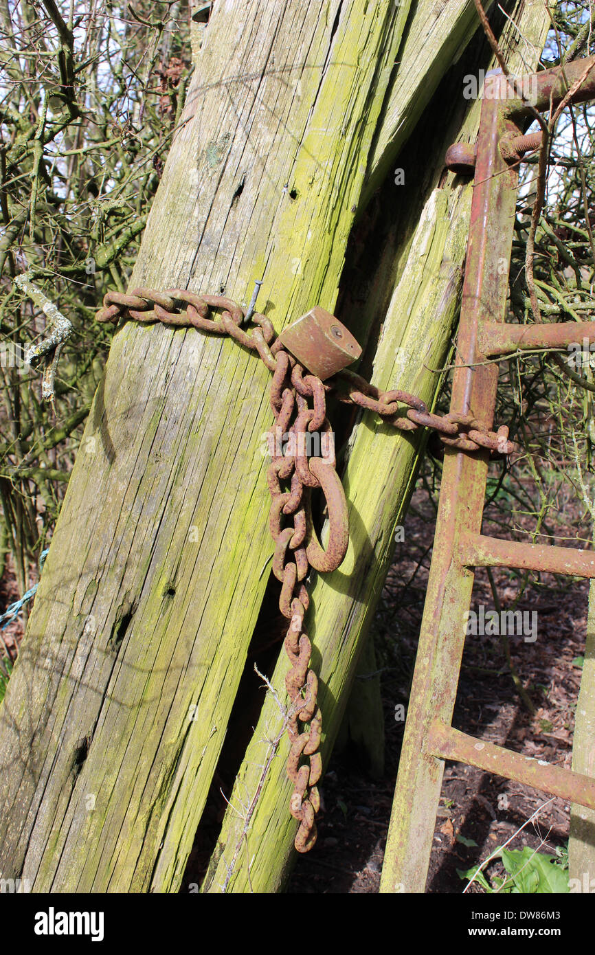 Serrure rouillée et sur la chaîne de production en métal leaning wooden post Banque D'Images