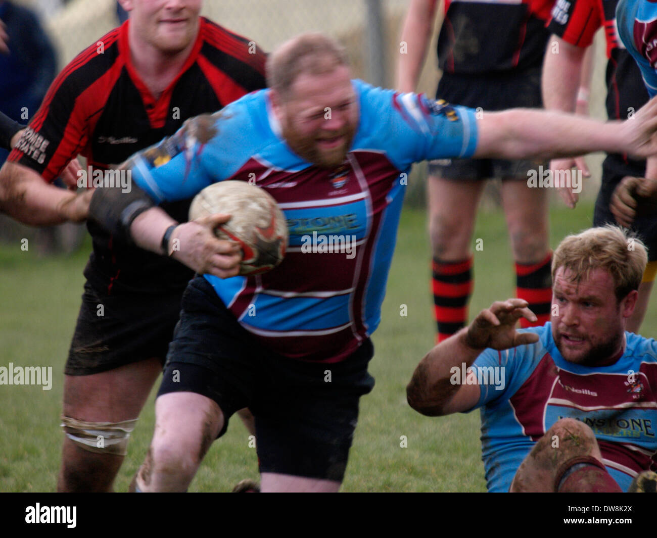 Grand joueur de rugby avant le chargement de l'avant, avec le flou, Bude, Cornwall, UK Banque D'Images
