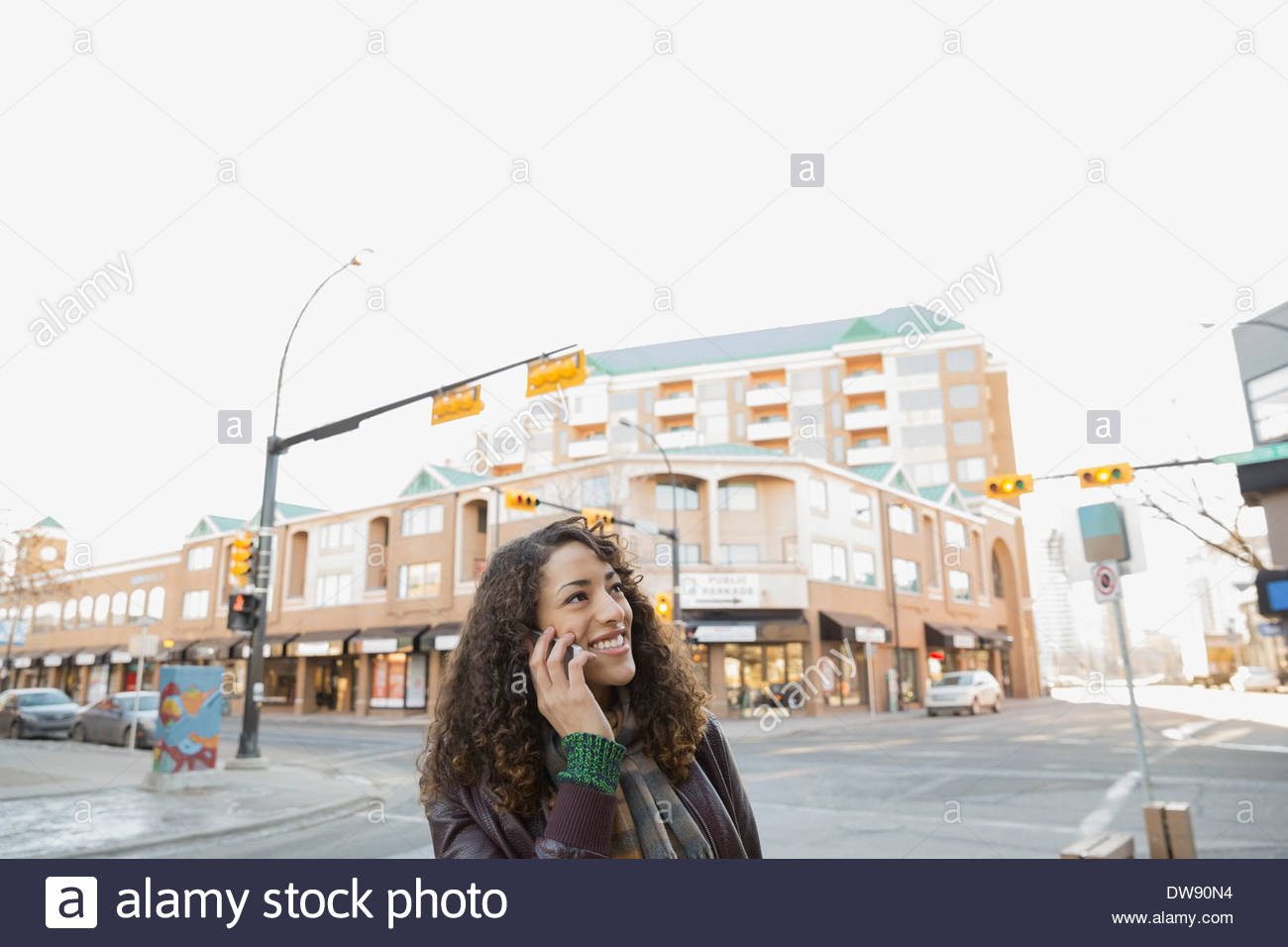Smiling woman répondre à smart phone on city street Banque D'Images