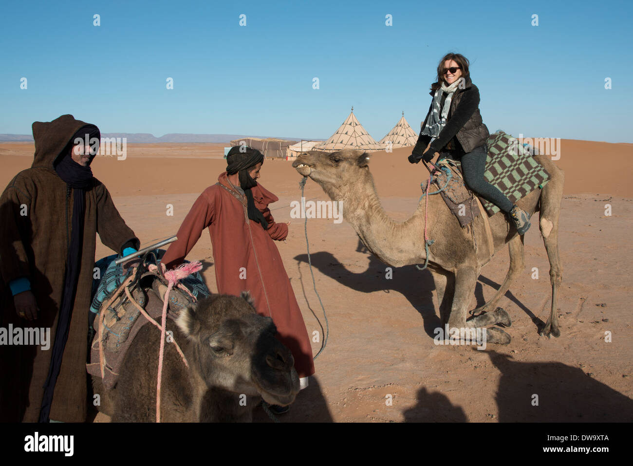 Les gens avec des chameaux dans un désert, Erg Chigaga Luxury Camp dans le désert, désert du Sahara, Maroc, Souss-Massa-Draa Banque D'Images