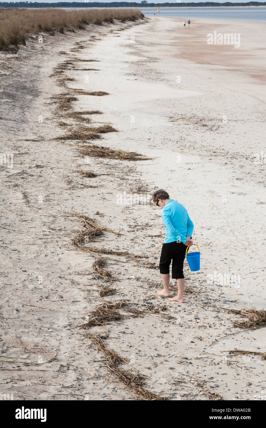 Femme à la recherche des coquillages sur la plage de Fort Clinch State Park sur Amelia Island, Floride Banque D'Images