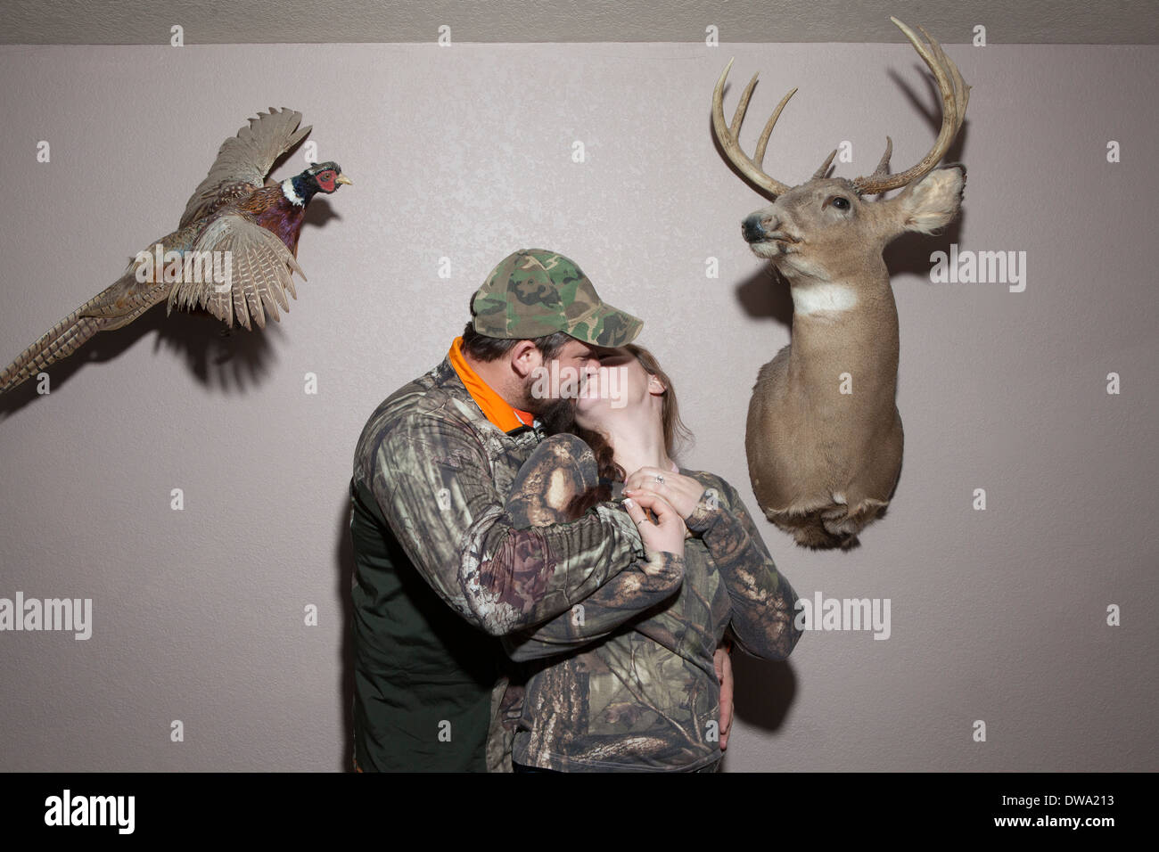 Couple baisers avec la taxidermie animale sur les murs Banque D'Images
