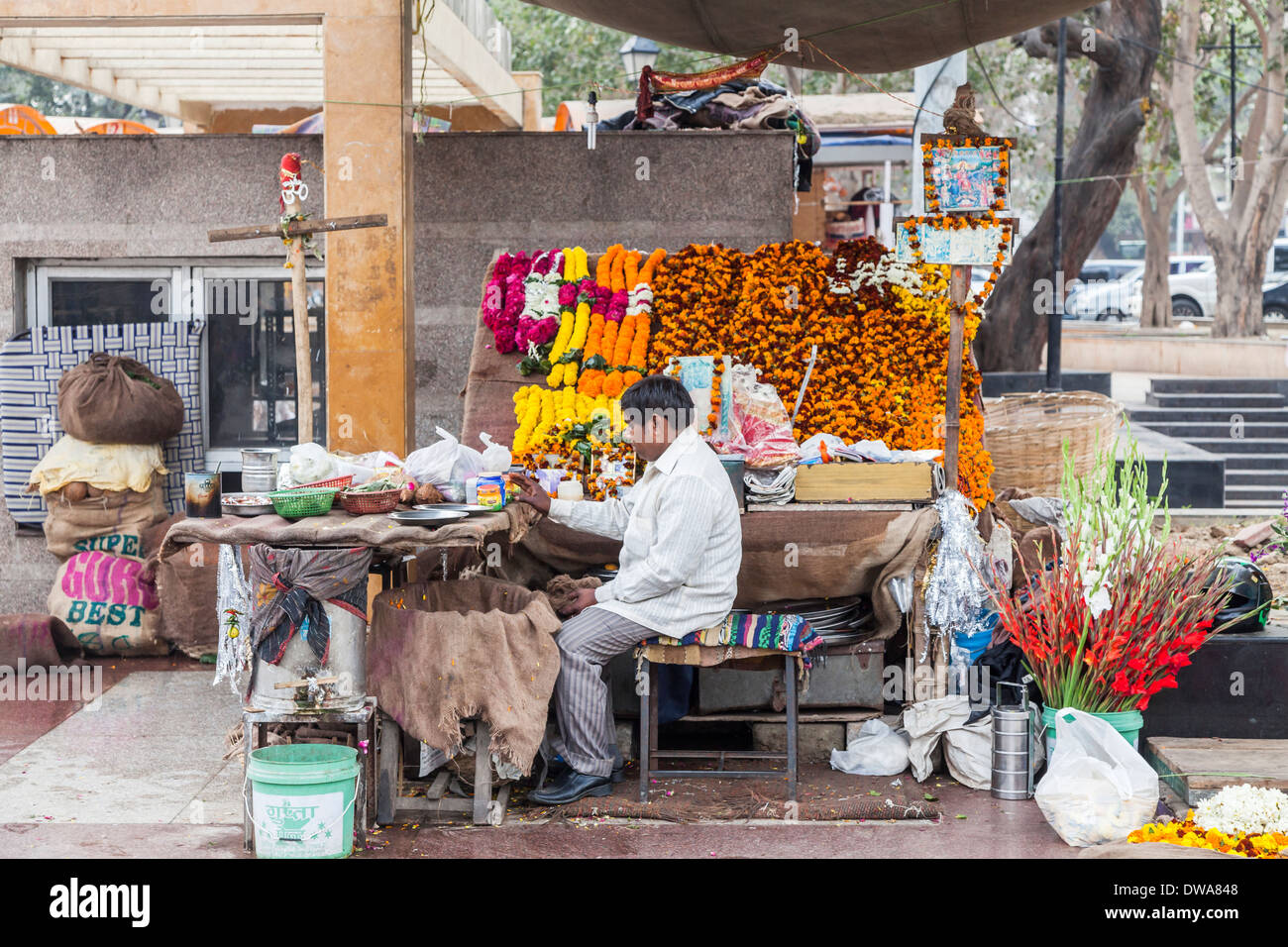 L'homme indien local à street flower stall à New Delhi, en Inde, la vente de fleurs et de guirlandes pour les offrandes au temple hindou Banque D'Images