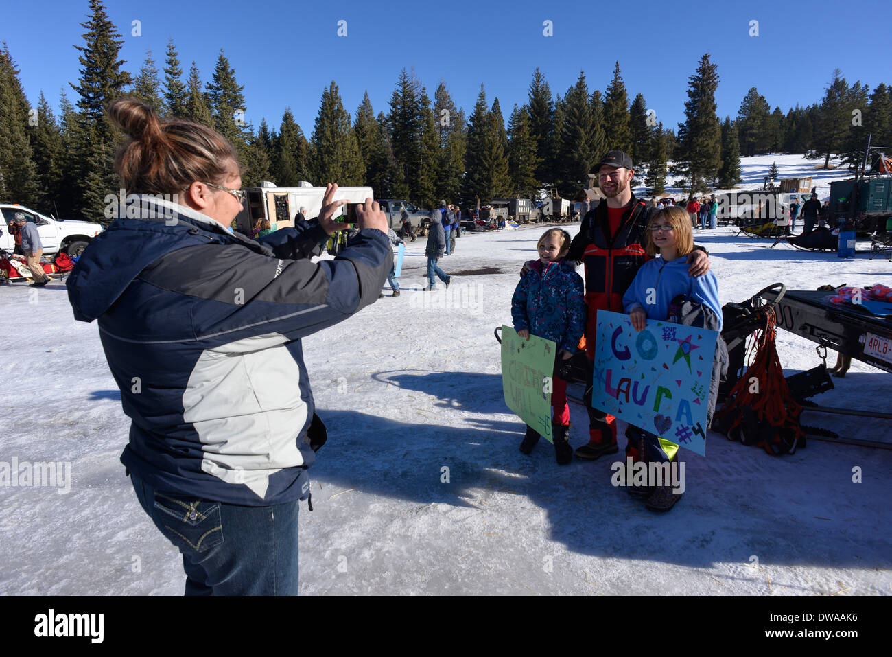 Woman taking photo d'un musher et les jeunes à l'Aigle Cap boosters Extreme Course de luge de chien dans les montagnes de l'Oregon Wallowa. Banque D'Images