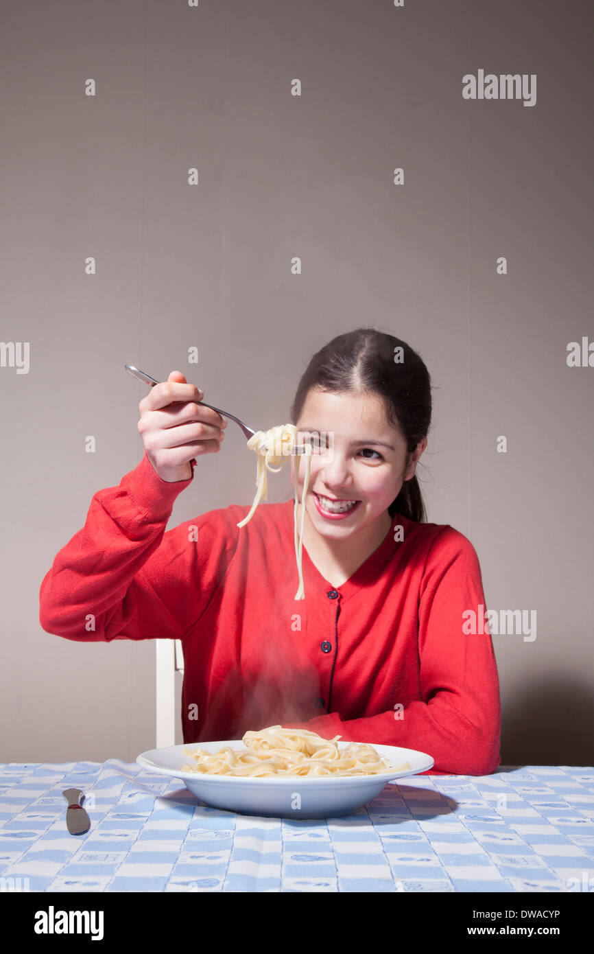 Teenage girl eating pasta Banque D'Images