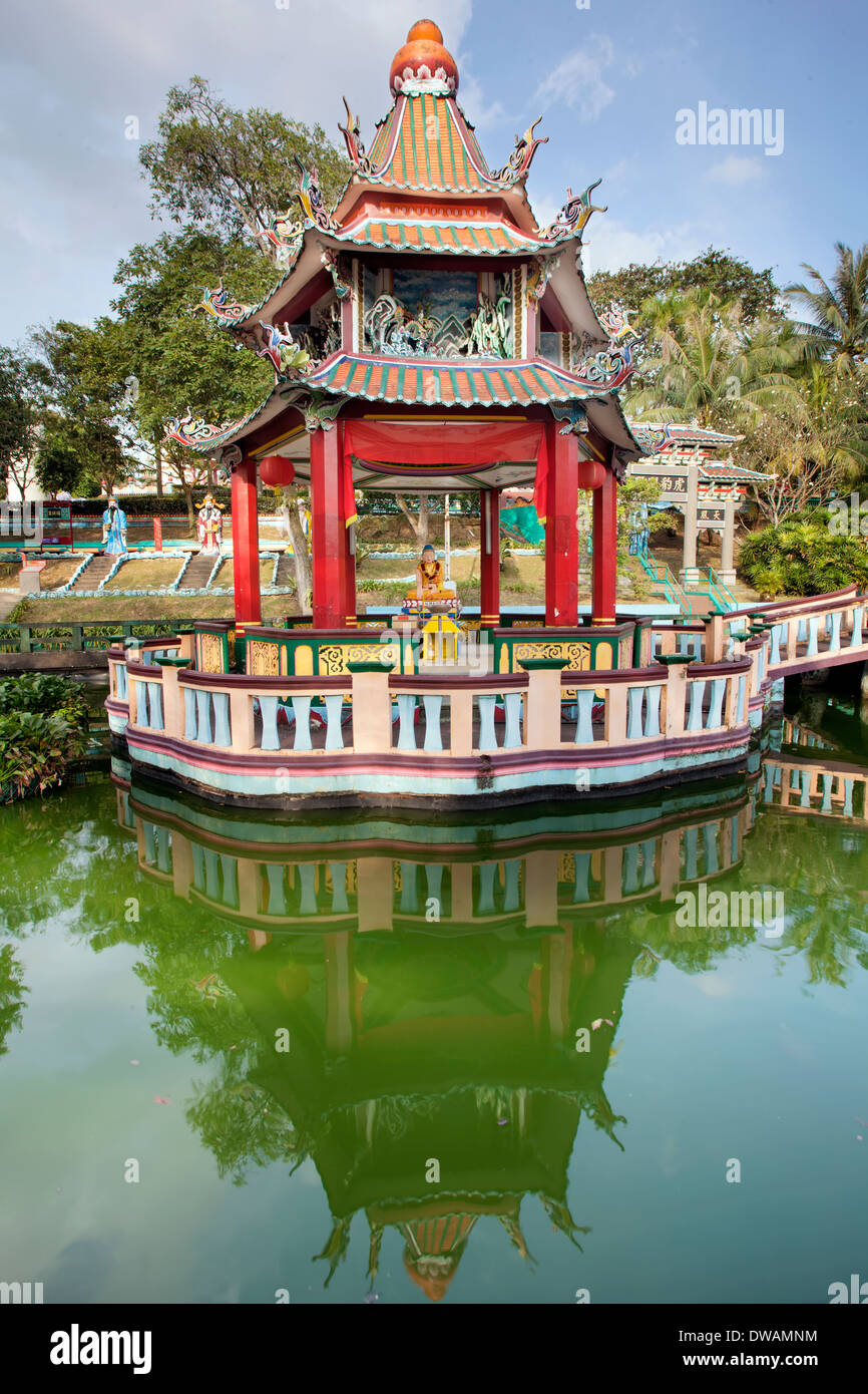 Singapour - 1 février 2014 : Statue de Bouddha autel dans pavillon chinois par le lac à Haw Par Villa Parc à thème. Banque D'Images