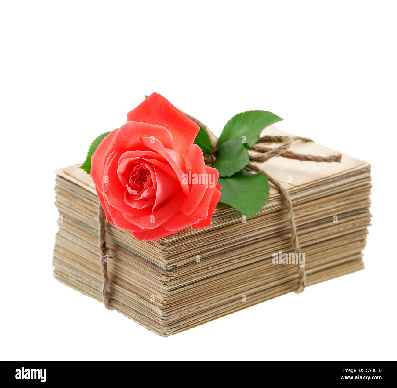 Pile d'anciennes lettres d'amour et de cartes postales avec des fleurs rose rouge isolé sur fond blanc. Photo sentimental nostalgique Banque D'Images