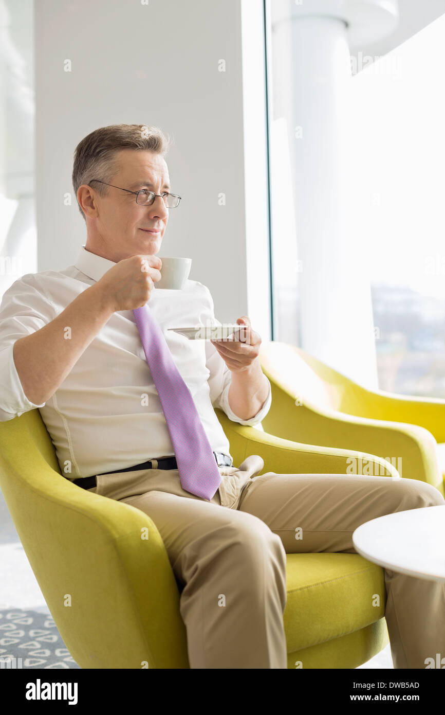 Mature businessman having coffee in lobby at office Banque D'Images Mature businessman having coffee in lobby at office Banque D'Images