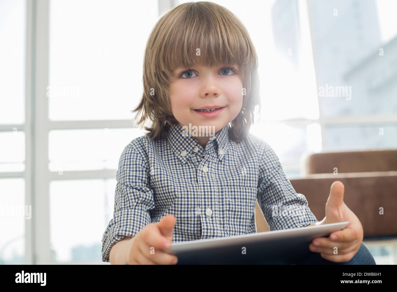 Portrait of cute boy holding tablet computer at home Banque D'Images