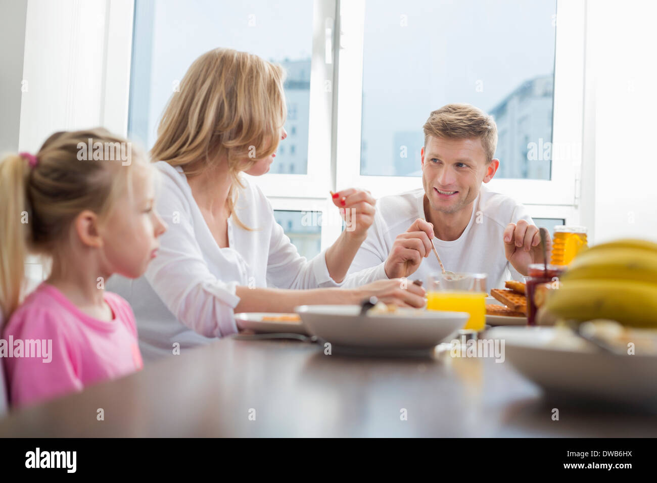 Une famille heureuse de trois le petit-déjeuner à table Banque D'Images