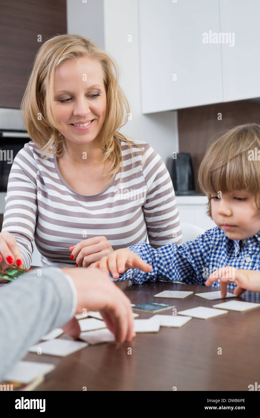 Garçon jouant aux cartes avec les parents à la maison Banque D'Images