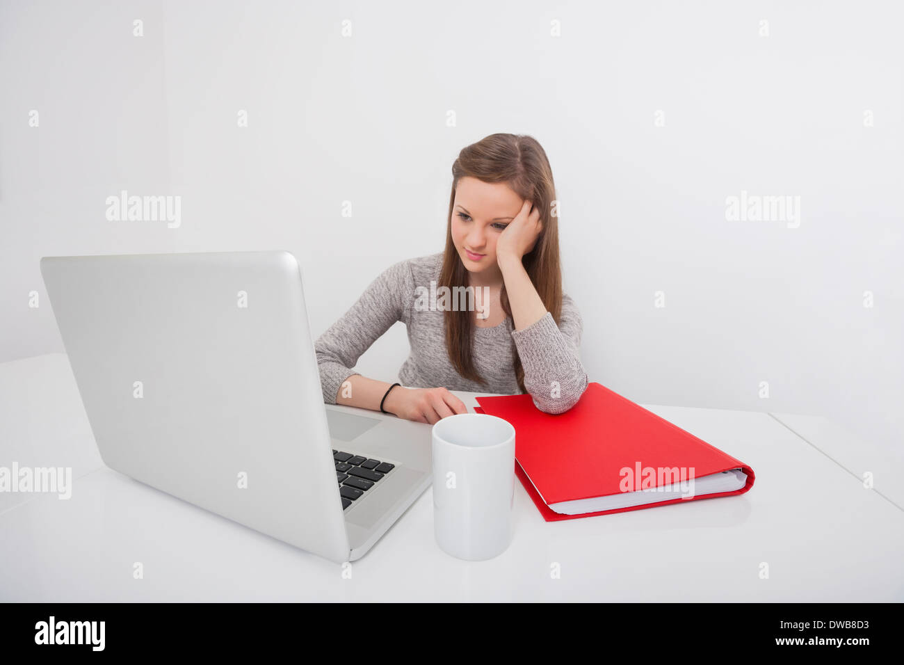 Belle businesswoman looking at laptop in office Banque D'Images
