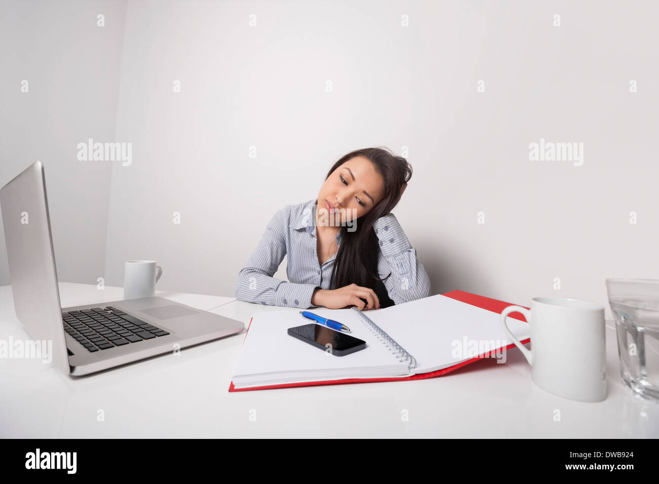 Bored businesswoman working at office desk Banque D'Images