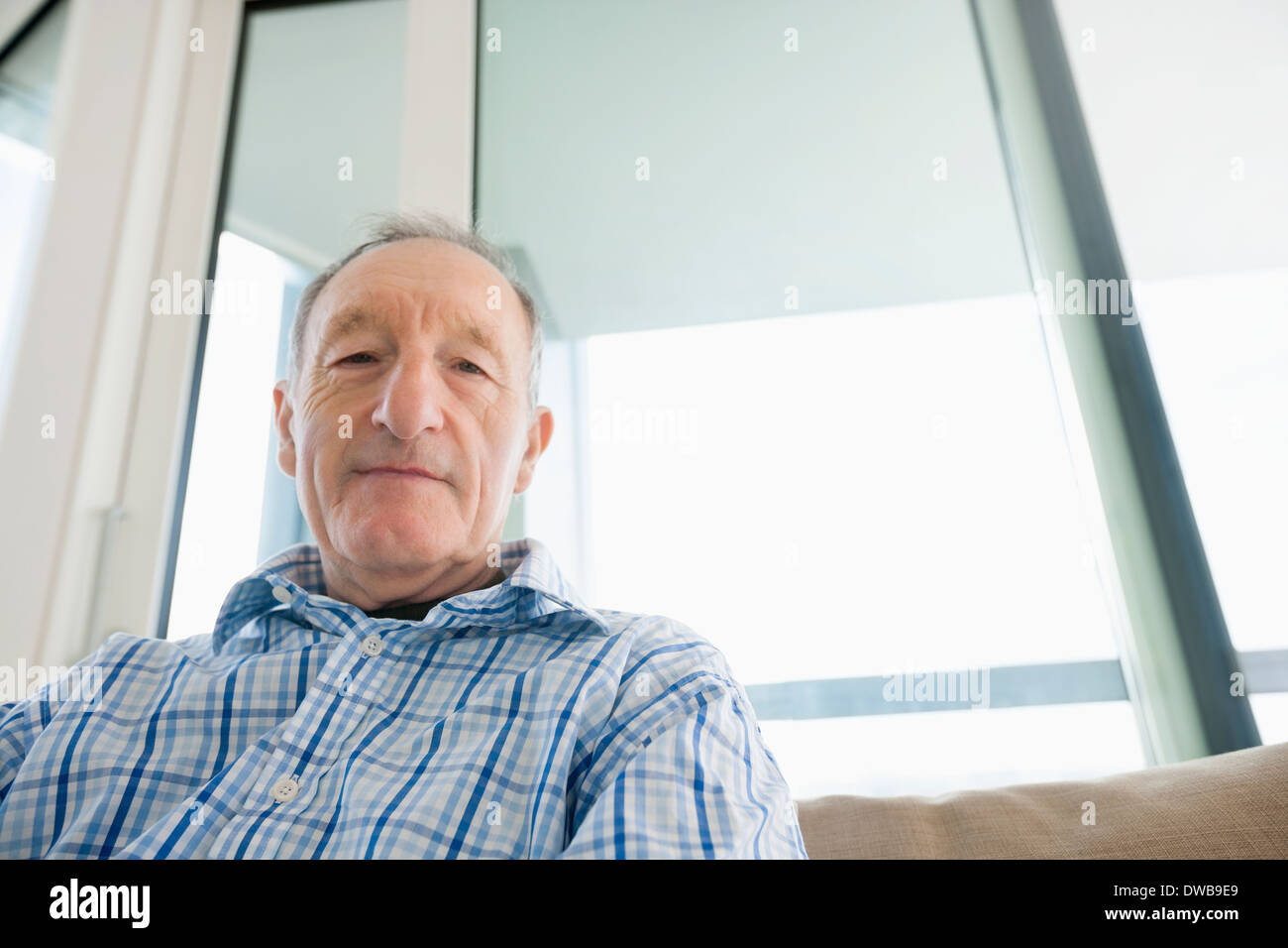 Portrait of senior man relaxing in living room Banque D'Images