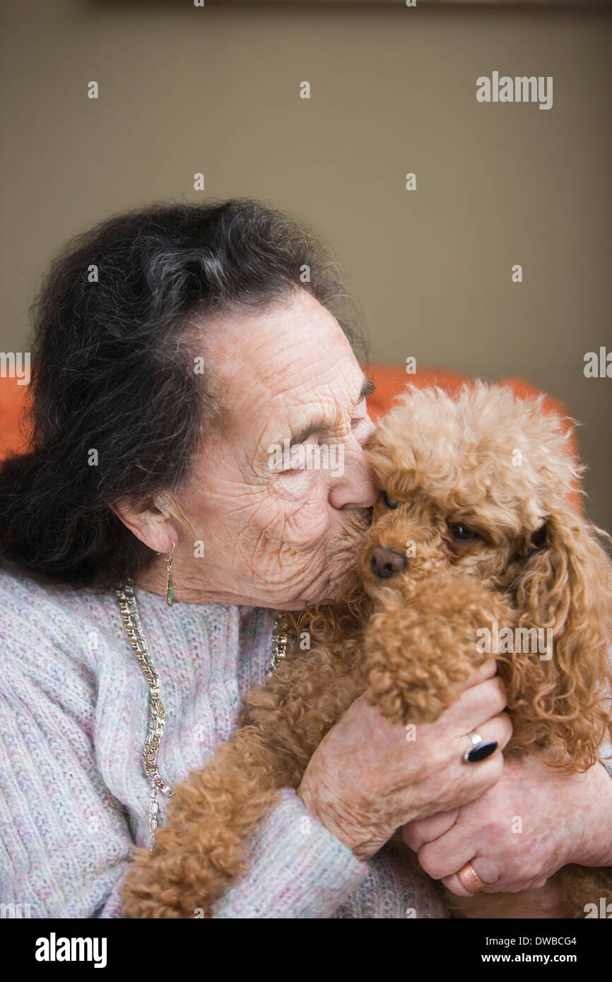 Senior woman kissing dog Banque D'Images
