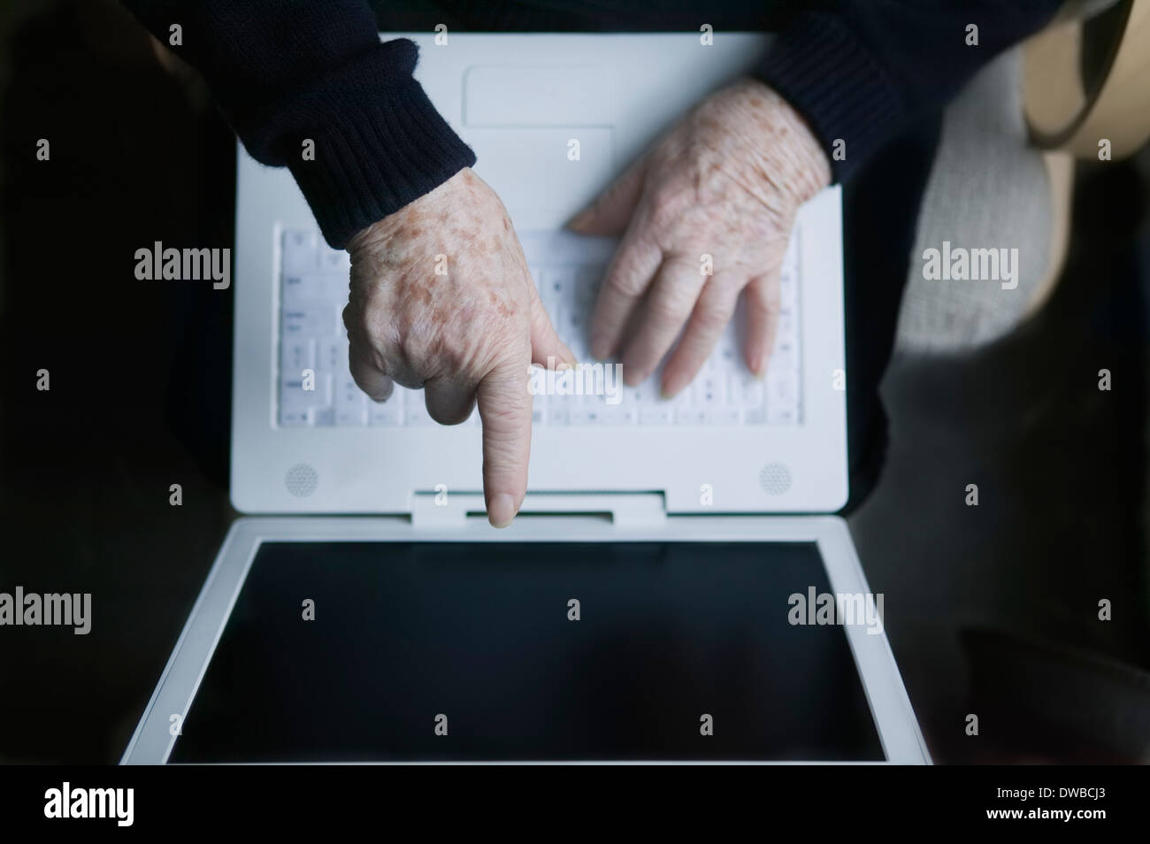 Senior woman pointant sur un écran d'ordinateur portable Banque D'Images