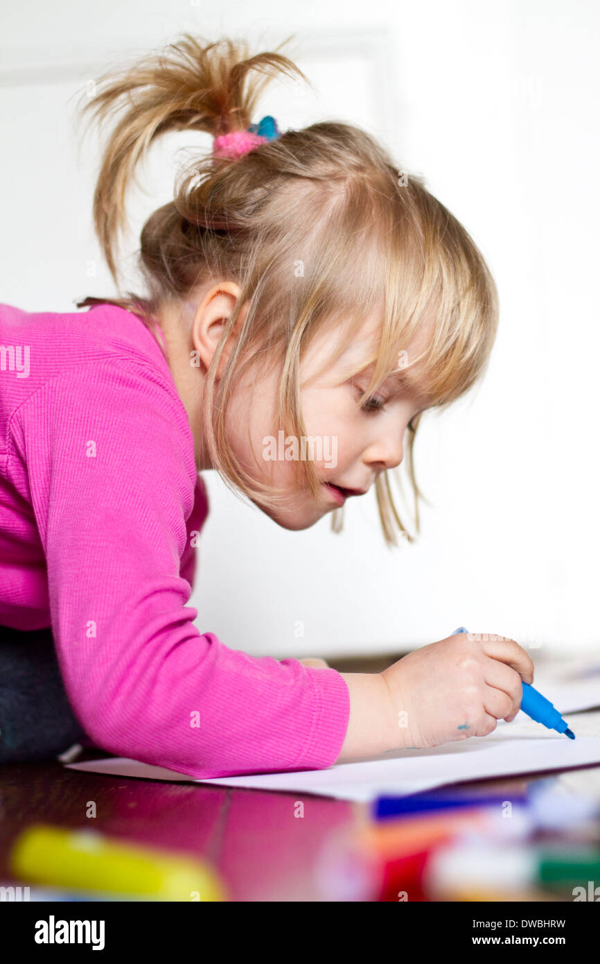 Petite fille peinture avec feutre bleu Banque D'Images